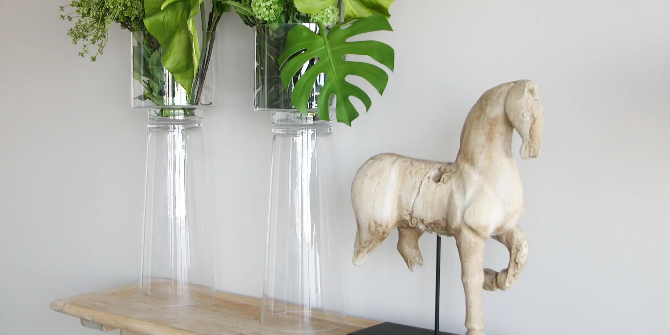 Detalhe de decoração, os apontamentos finais após um trabalho de remodelação de interiores. Pormenor de escultura em madeira e dois elegantes arranjos florais.